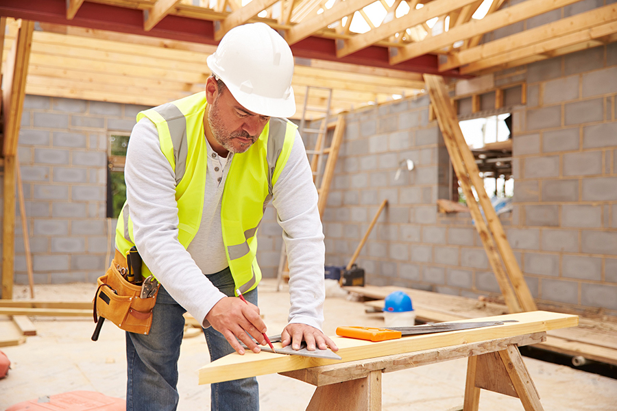 image of construction site and worker measuring